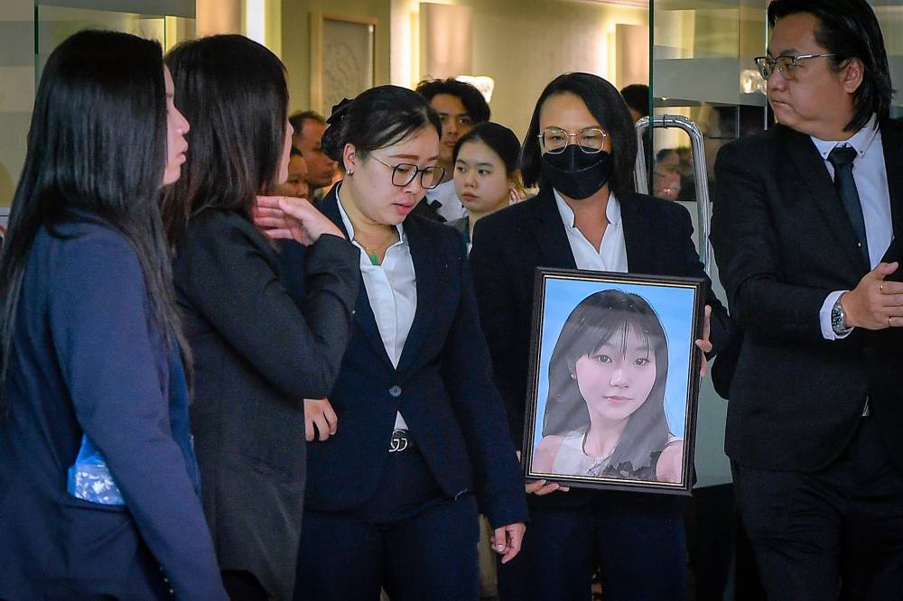 Emotional scene of family mourning 16-year-old girl after Bandar Utama school stabbing, prompting discussion on school violence, MOE school policy reforms, and school caning.