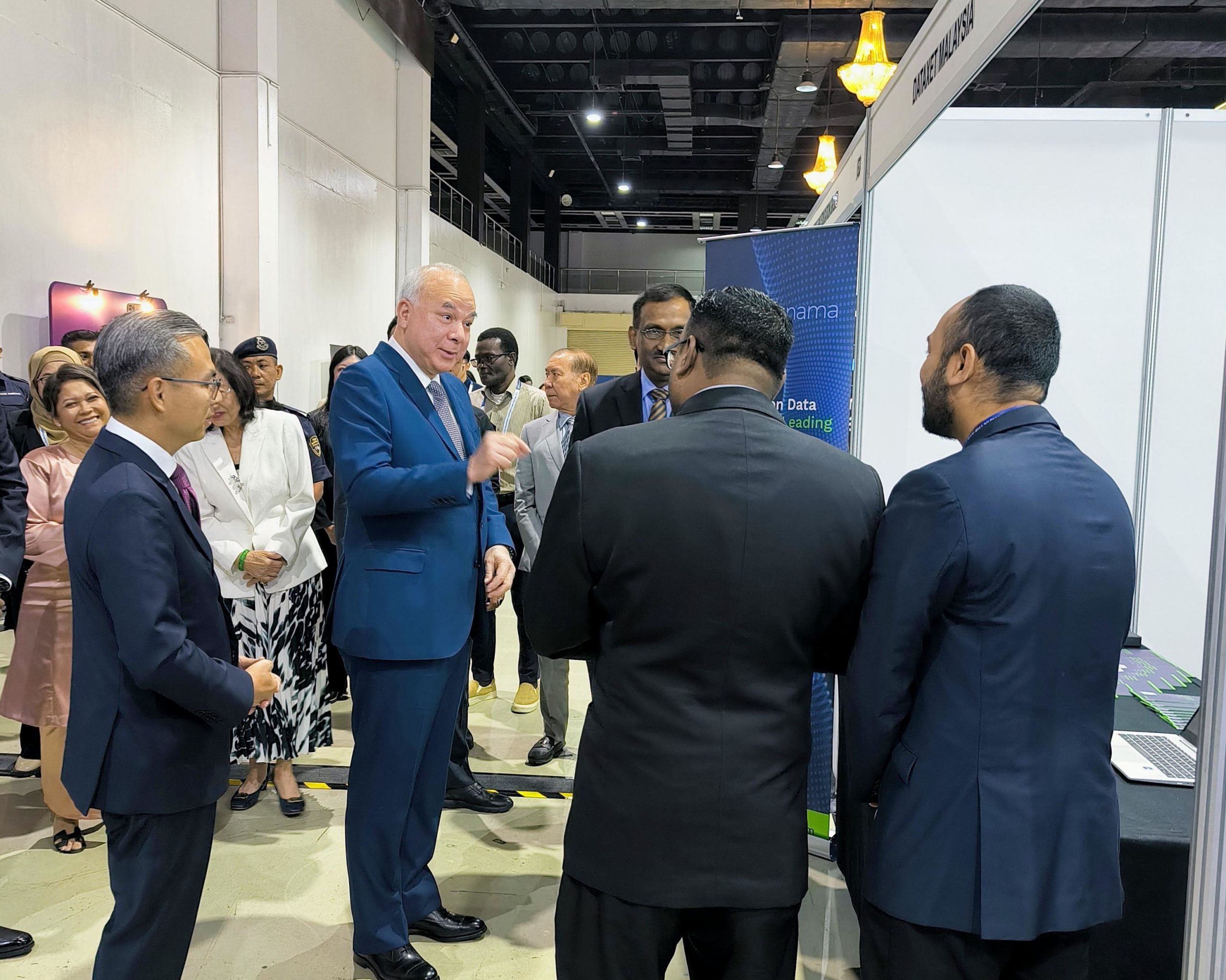 Sultan Nazrin Muizzuddin Shah and Minister Fahmi Fadzil converse with attendees at the Dataxet Malaysia booth during GPRCF 2025, interacting with the company's showcased AI-powered media intelligence and social listening solutions.